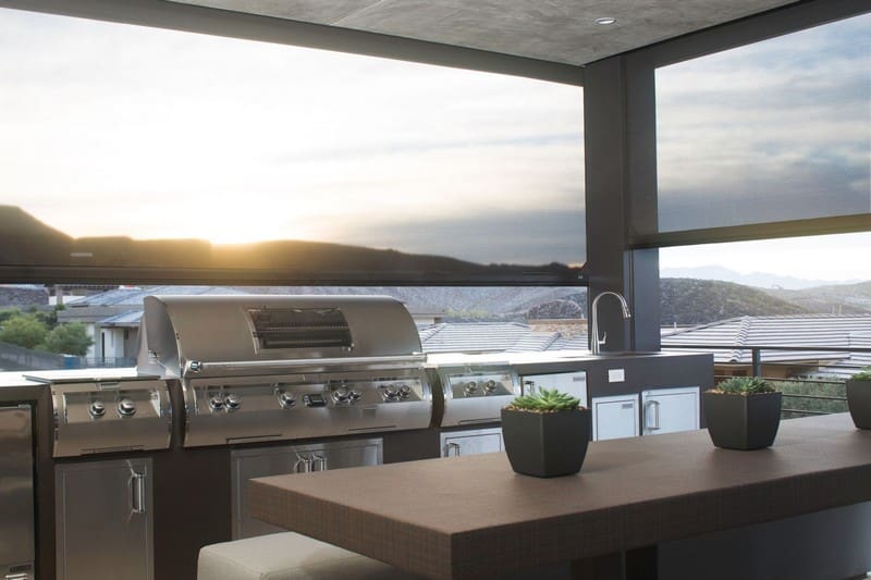 Outdoor kitchen area on balcony with retractable motorized screens